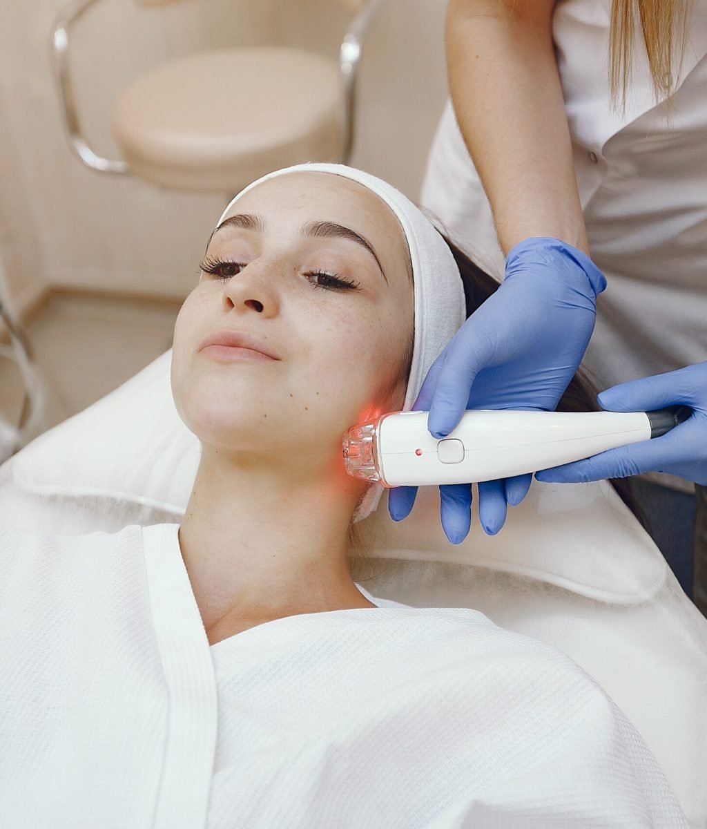 Cosmetologist use laser. Woman with cosmetologist. Lady in a beauty studio.